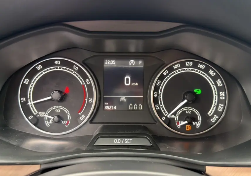 Vue centrée sur le volant cuir noir et le combiné d'instruments numérique du Skoda Kamiq 2023, tableau de bord bois clair.