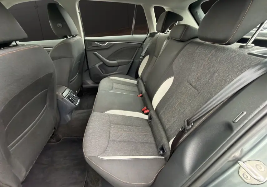 Vue rapprochée du tableau de bord du Skoda Kamiq 2023, écran tactile central affichant SmartLink, finition bois clair.