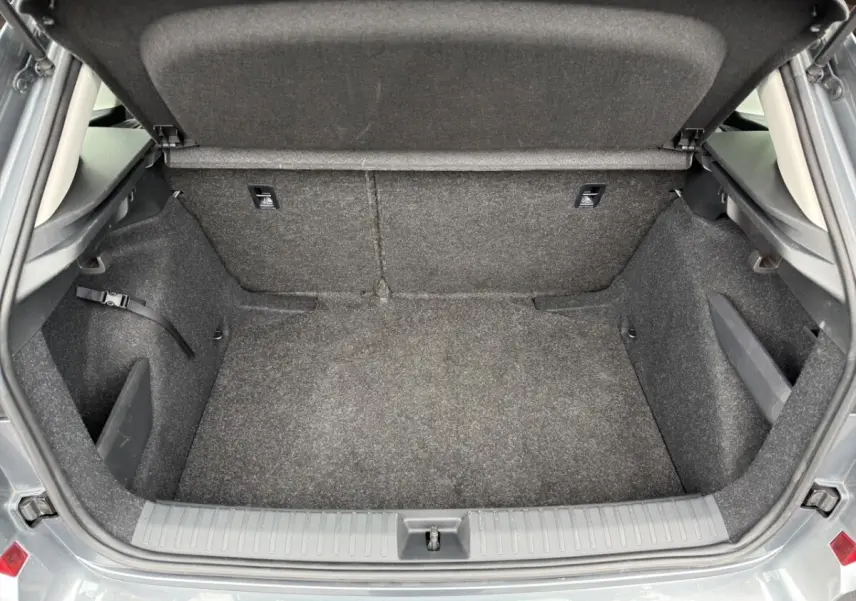 Vue intérieure arrière côté gauche du Skoda Kamiq gris foncé, sièges tissu bi-ton avec surpiqûres orange.