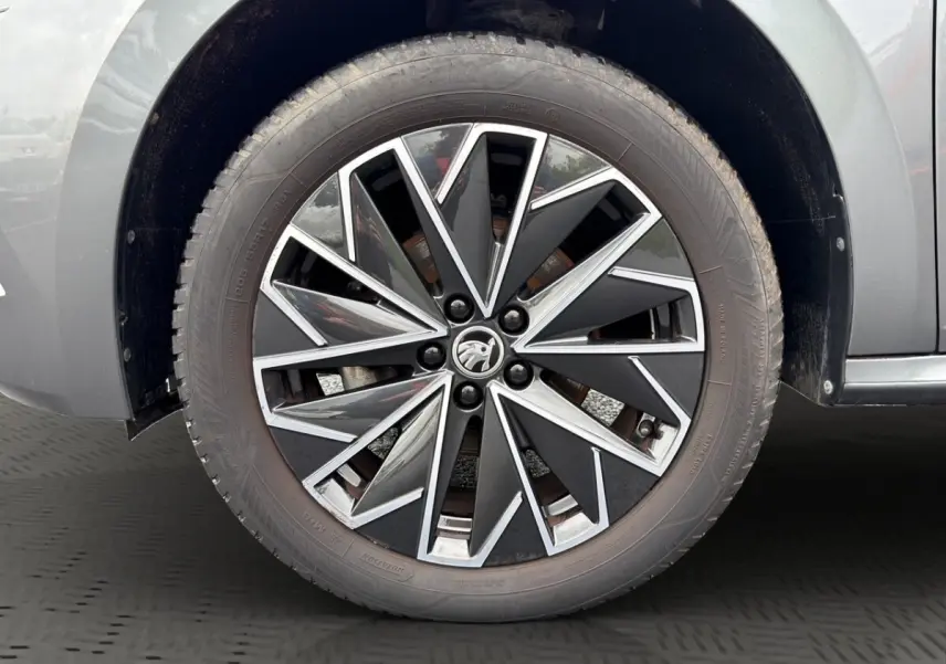 Vue avant d'un Skoda Kamiq gris foncé avec calandre noire et logo centré, présenté en showroom Distinxion.