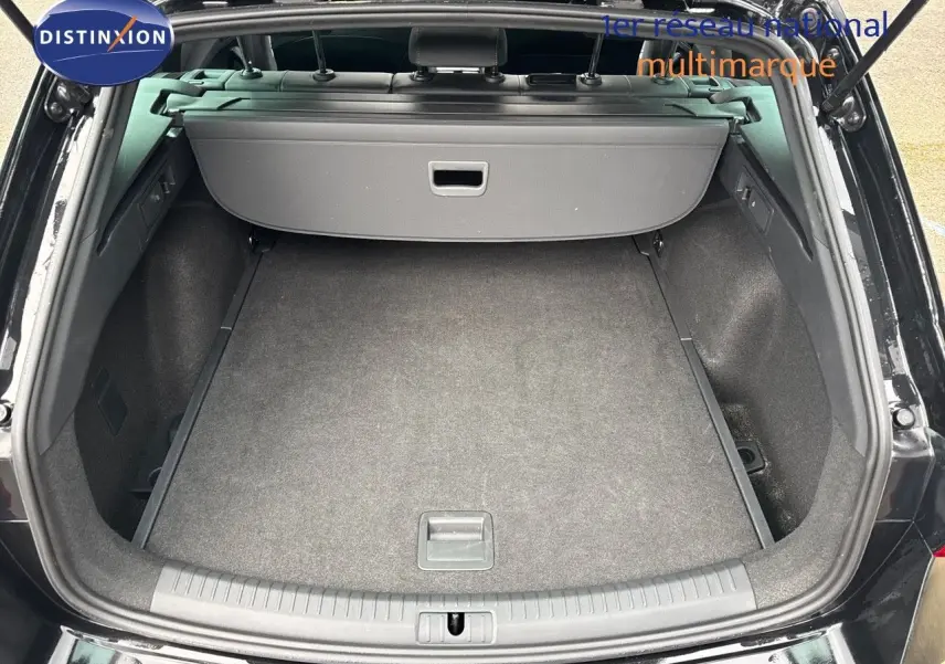 Coffre ouvert d'une CUPRA LEON ST noir midnight metal, vue arrière montrant l'espace de chargement vide et la plage arrière.
