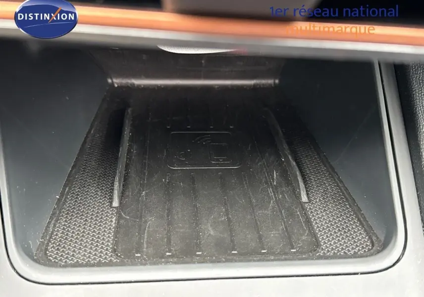 Gros plan sur le chargeur sans fil noir intégré dans la console centrale d'une CUPRA LEON ST 2024.