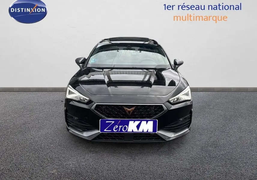 Vue frontale d'une CUPRA LEON ST noire Midnight Metal avec calandre distinctive et phares LED allumés.