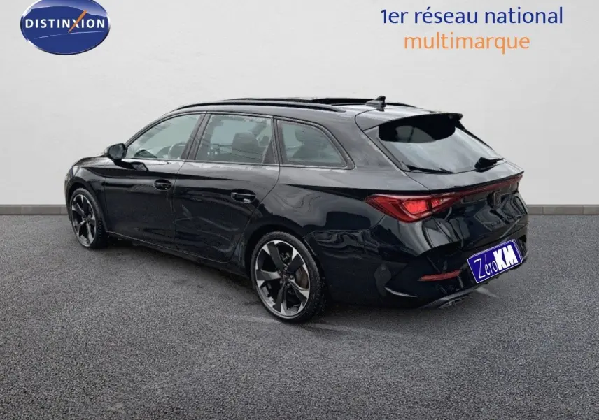 Vue 3/4 arrière droite d'une CUPRA LEON ST noire Midnight Metal avec jantes biton et feux LED arrière distinctifs.