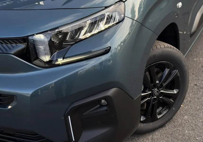 Gros plan sur l'avant droit bleu métallisé du Citroën Berlingo Multispace avec phare LED et jante alliage noire.