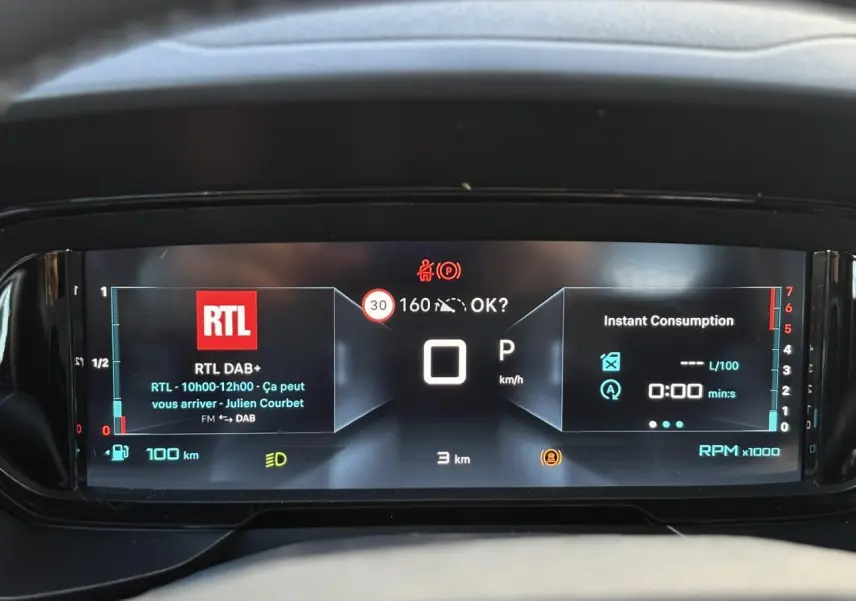 Combiné numérique 10 pouces du Citroën Berlingo Multispace 2025 affichant la radio RTL et la consommation instantanée.
