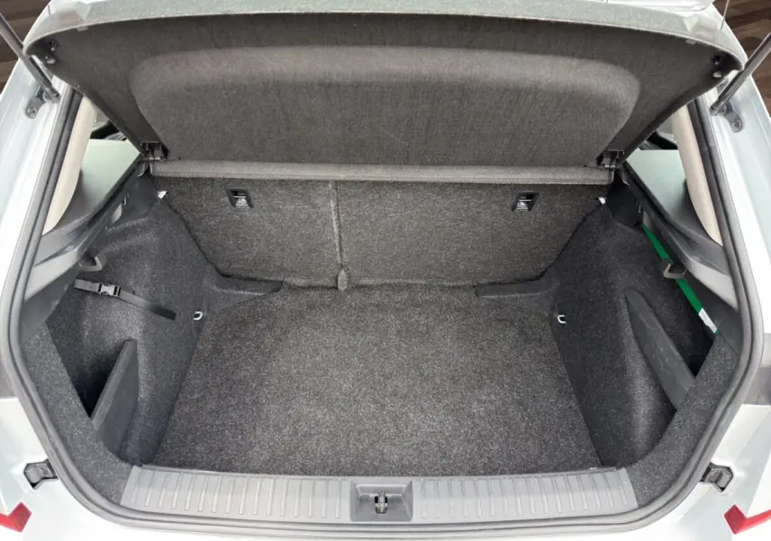 Vue intérieure arrière droite du Skoda Kamiq 2023 gris clair, montrant les sièges tissu et les aérateurs centraux.