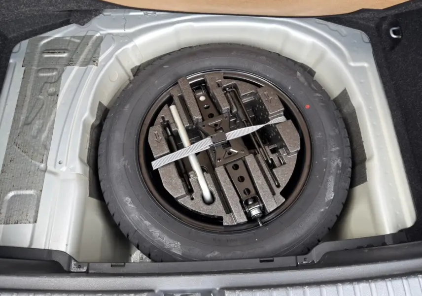 Coffre ouvert vu de l'arrière d'un Skoda Kamiq gris clair 2023 avec intérieur de coffre en tissu gris.