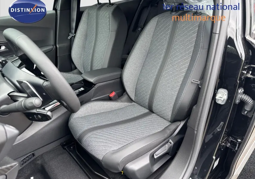 Vue intérieure côté conducteur du Peugeot 2008 HYBRID 136CH Allure 2025, sièges tissu gris et cuir noir, portière ouverte.