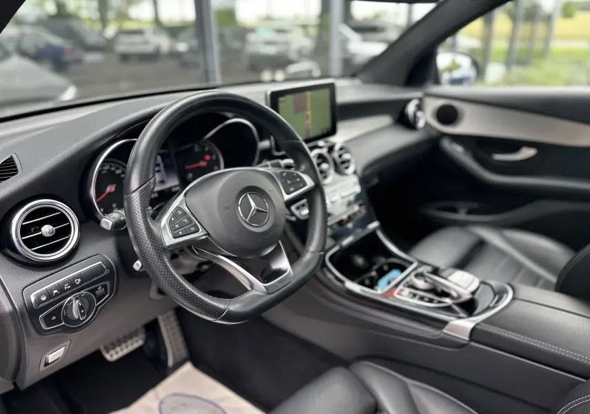 Vue intérieure côté conducteur du Mercedes GLC Coupé 250 D Fascination 2018 avec tableau de bord noir et écran central.