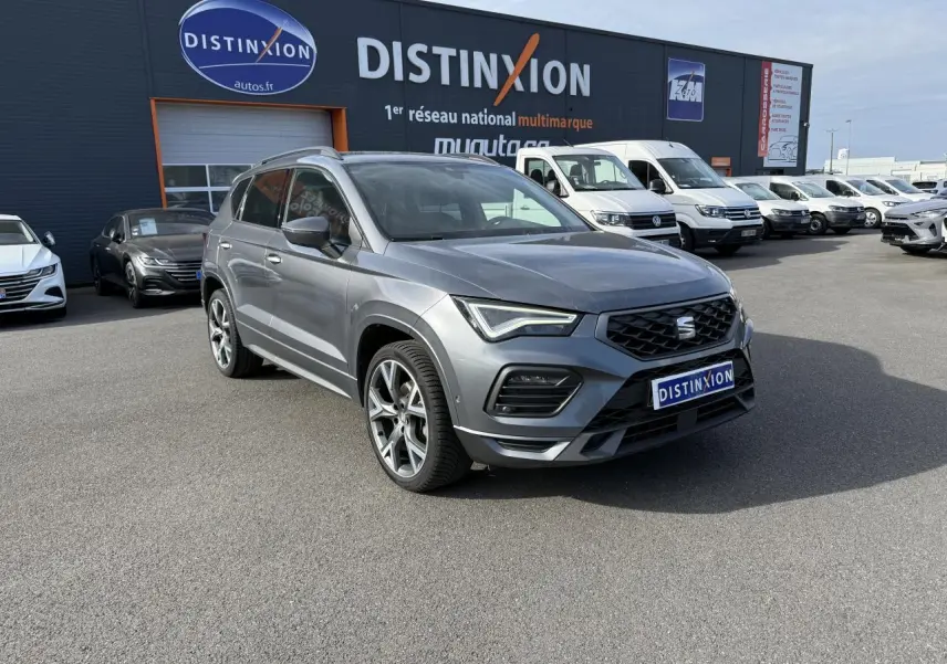 SEAT Ateca gris graphite en 3/4 avant droit avec jantes alu 19 pouces, stationné devant un concessionnaire Distinxion.