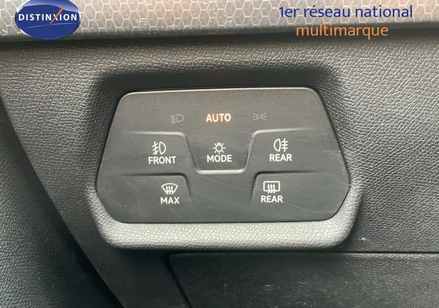 Gros plan sur les commandes d'éclairage et de désembuage du tableau de bord d'une SEAT LEON ST gris urbain 2023.