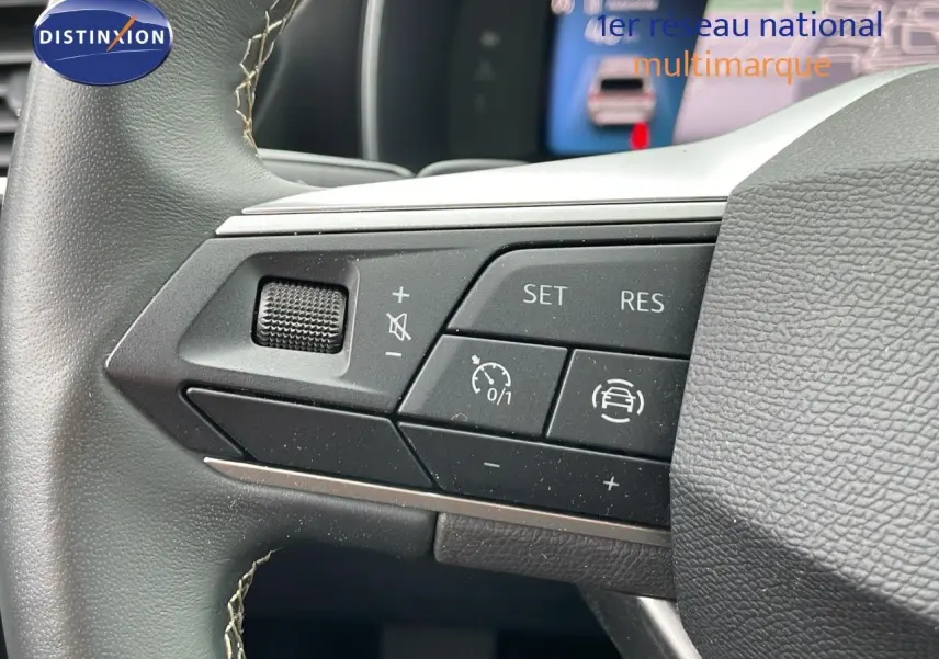 Gros plan sur les commandes au volant gauche de la SEAT LEON ST gris urbain 2023 avec régulateur de vitesse et assistance conduite.