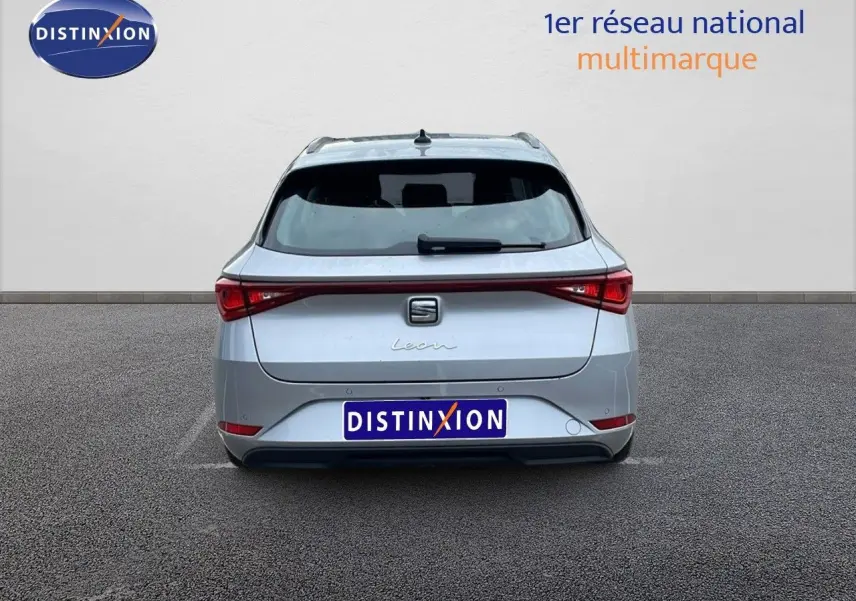 Vue arrière d'une SEAT LEON ST 2023 gris urbain, mettant en valeur ses feux arrière étirés et son hayon élégant.