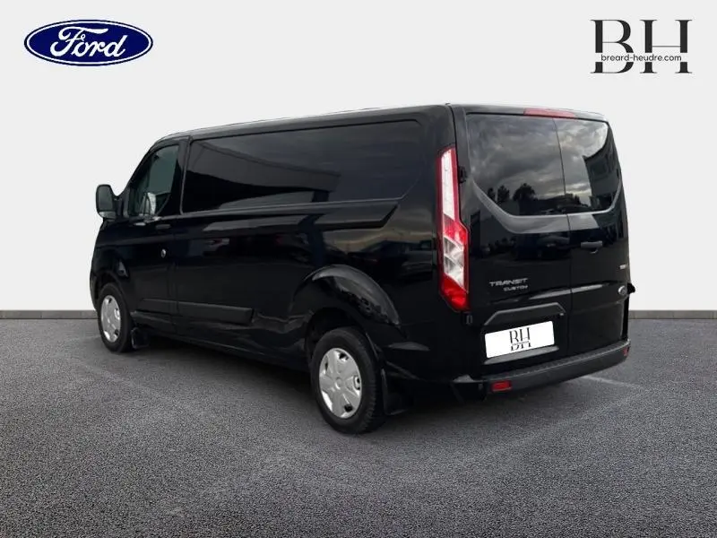Ford Transit Custom noir Agate métallisé vu en 3/4 arrière droit, portes battantes et feux arrière verticaux visibles