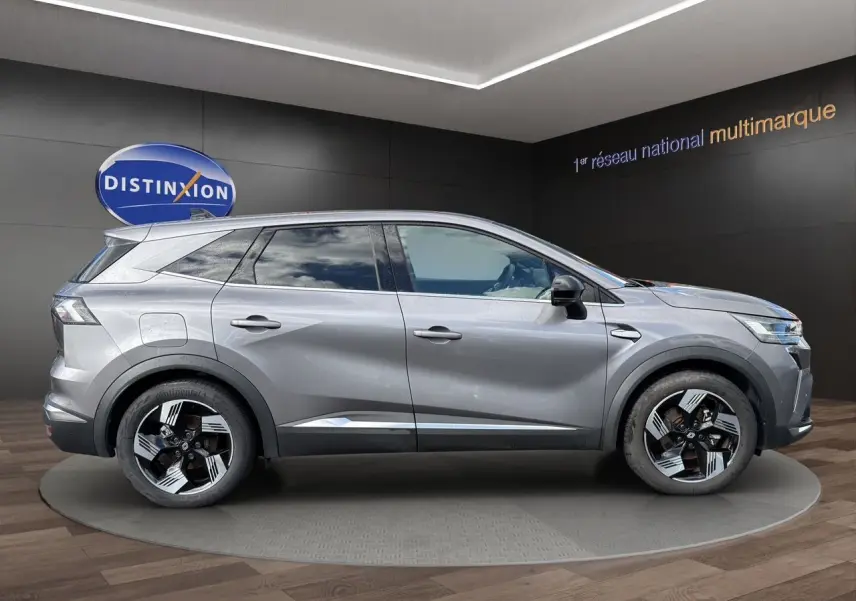 Profil droit du Renault SYMBIOZ gris clair 2025 avec jantes noires et détails chromés, présenté en intérieur showroom.