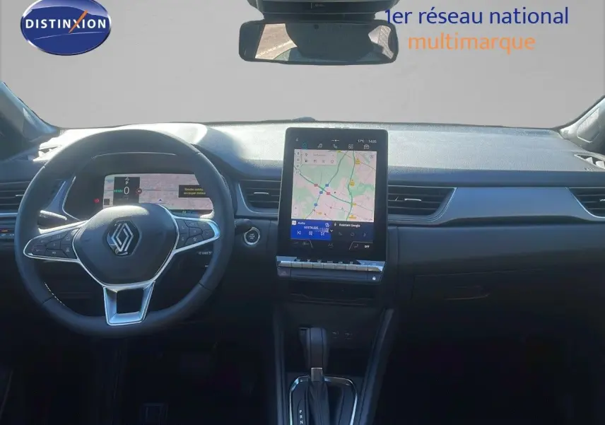 Vue intérieure du tableau de bord du Renault Captur E-Tech hybride 2025 avec écran tactile central et volant multifonction noir.