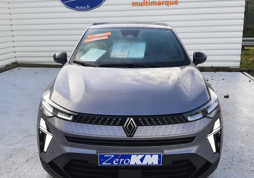 Vue de face du Renault Captur gris Cassiopée 2025 avec calandre moderne et feux LED distinctifs allumés.