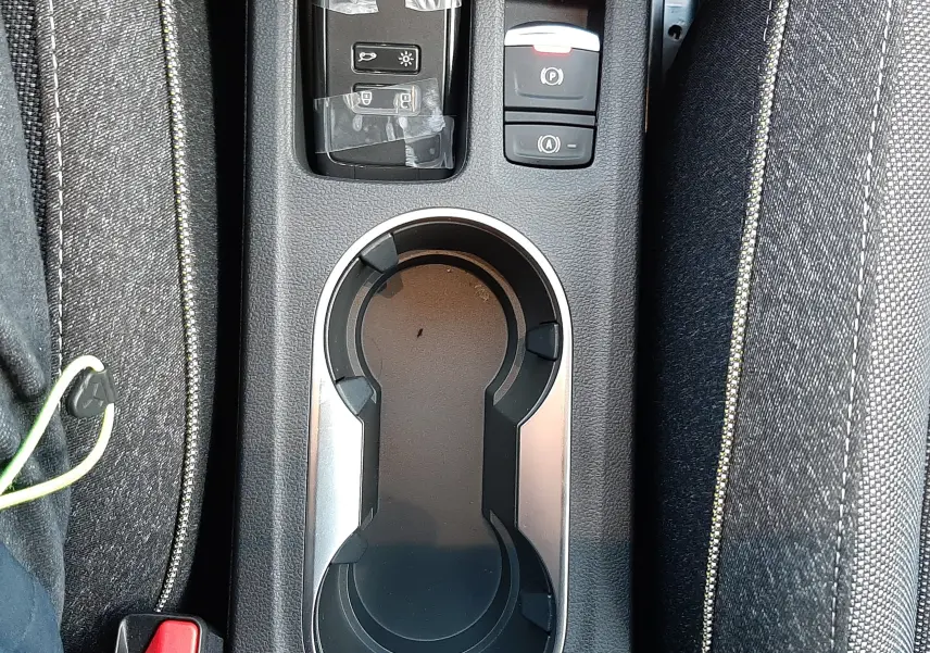 Vue plongeante sur la console centrale du Renault Captur gris Cassiopée, avec porte-gobelets et commandes électroniques.