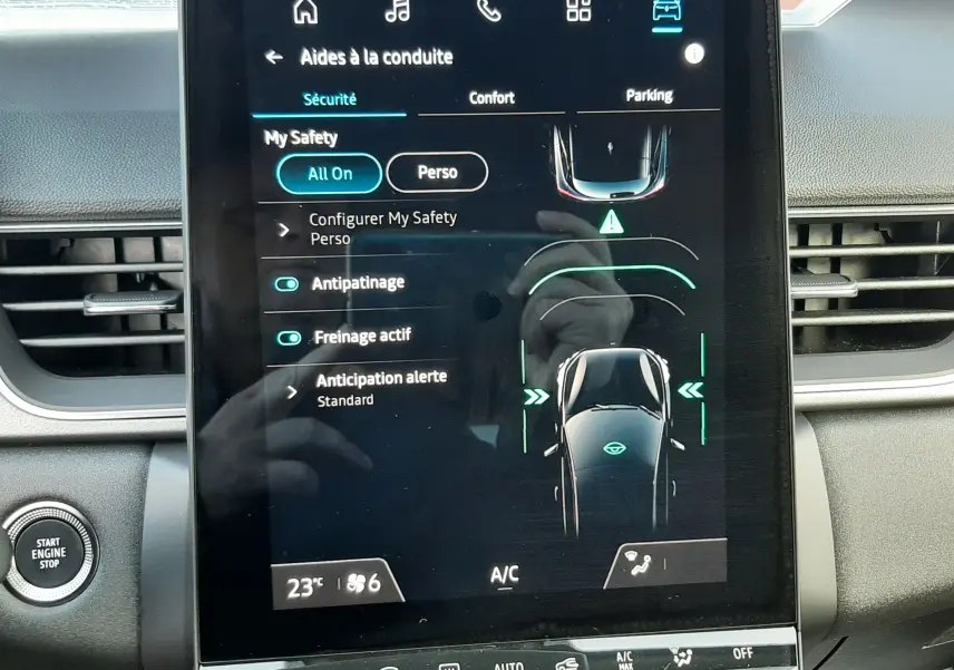 Écran tactile central du tableau de bord du Renault Captur 2025 affichant les aides à la conduite, intérieur noir.
