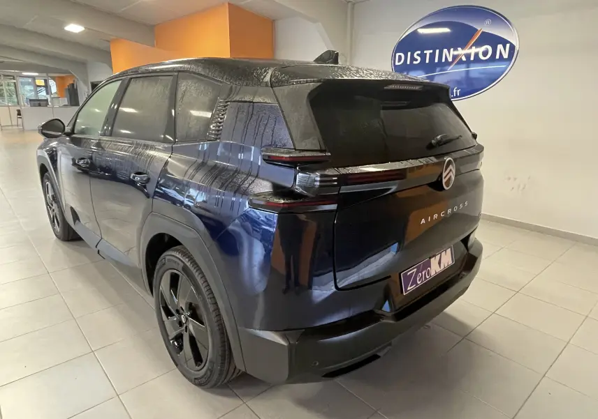 Vue 3/4 arrière droite d'un Citroën C5 Aircross hybride bleu Eclipse avec toit noir et feux arrière LED distinctifs.