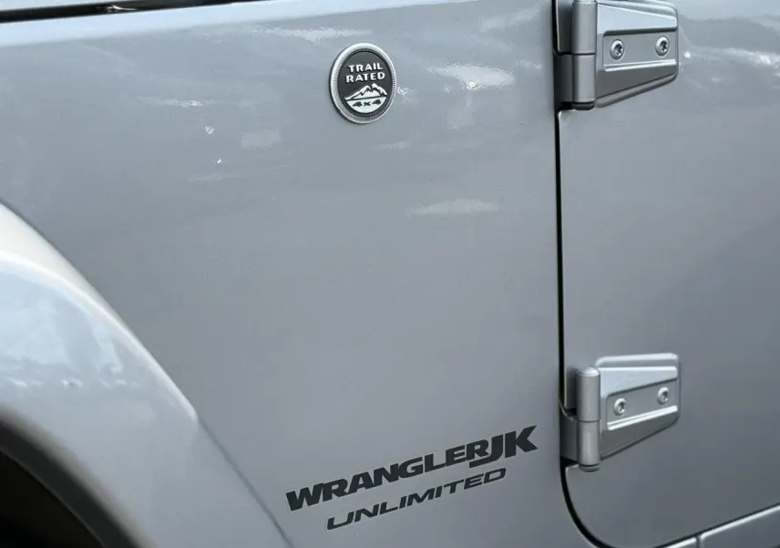 Gros plan sur la porte côté gauche d'une Jeep Wrangler JK Unlimited Billet Silver avec badge Trail Rated.