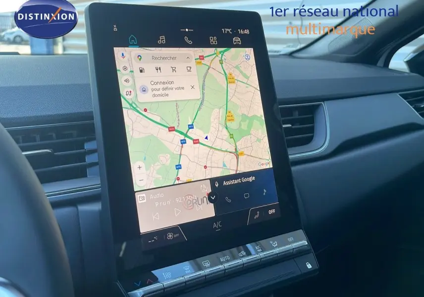 Vue intérieure du tableau de bord du Renault Captur blanc nacré 2025, avec écran tactile central affichant une carte GPS.