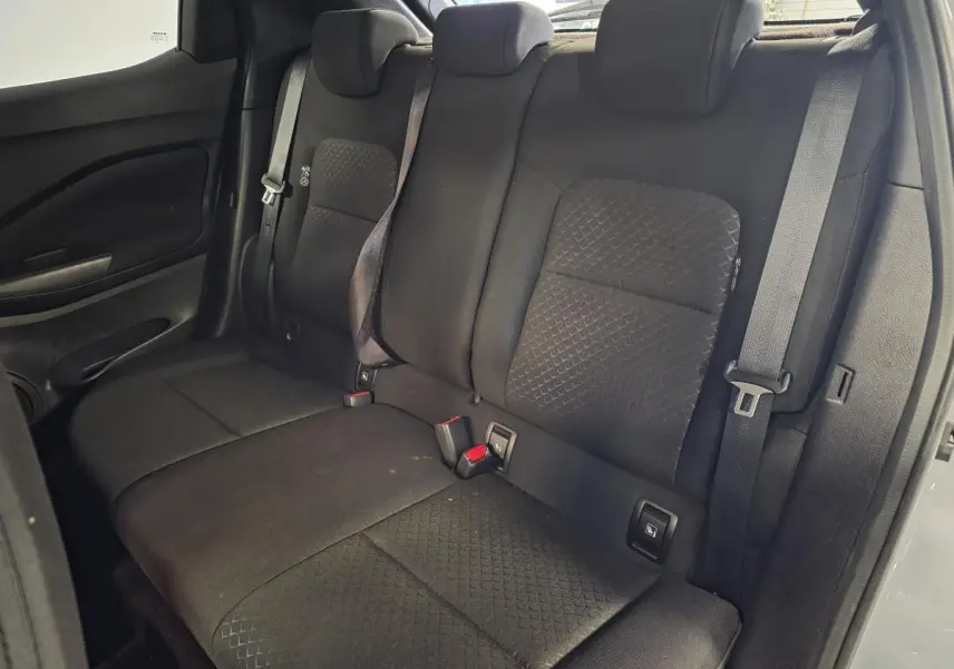 Banquette arrière noire du Nissan Juke 2023 vue de côté droit avec trois appuis-tête réglables et ceintures de sécurité.