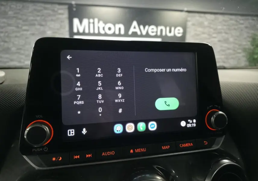 Écran tactile central du tableau de bord du Nissan Juke 2023 affichant le composeur téléphonique en intérieur noir.