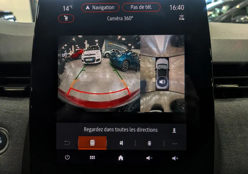 Écran central montrant la caméra 360° d'une Renault Clio V Rouge Flamme en marche arrière dans un garage.