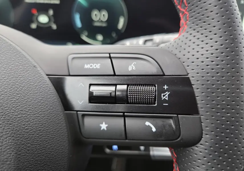 Gros plan sur les commandes gauche du volant perforé noir avec surpiqûres rouges du Hyundai Tucson N Line 2025.