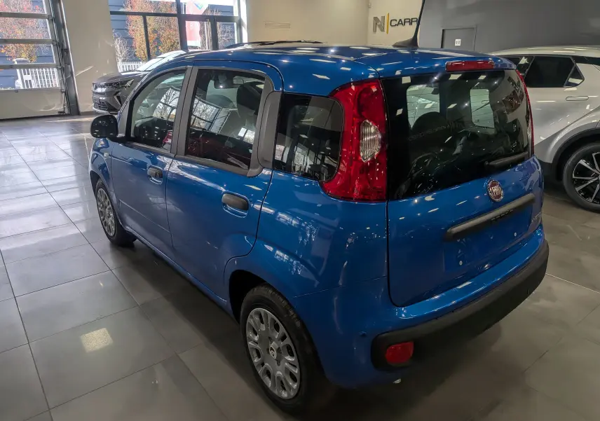 Vue 3/4 arrière droite d'une Fiat Panda 1.0 Hybrid 2025 en Bleu Italia, avec feux arrière verticaux et vitrage teinté.