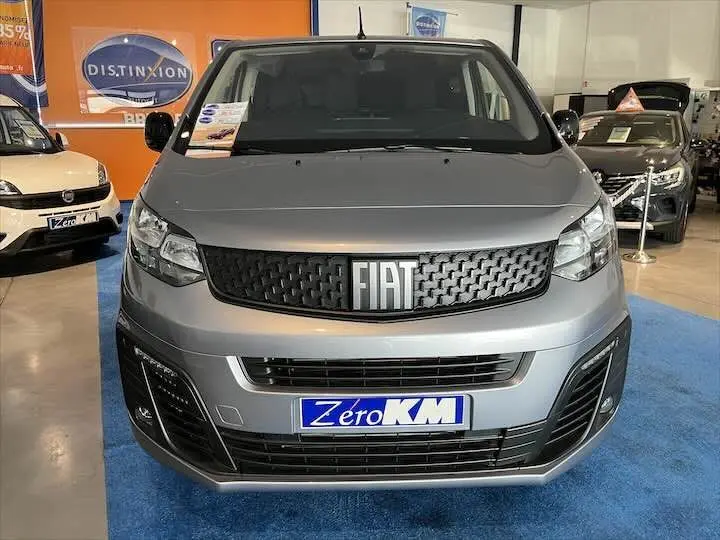 Vue frontale d'un FIAT Scudo cabine approfondie gris Artense métal exposé en showroom avec plaque Zero KM visible.
