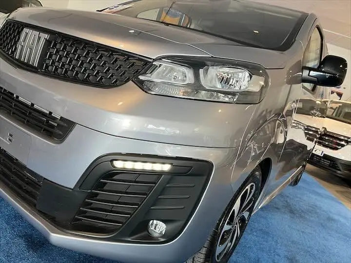 Vue 3/4 avant droit d'un FIAT Scudo cabine approfondie gris Artense métallisé avec feux LED et calandre noire.