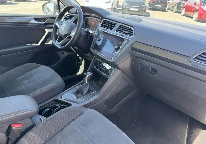 Intérieur avant du Volkswagen Tiguan gris, vue côté conducteur montrant le tableau de bord et la console centrale avec boîte auto.