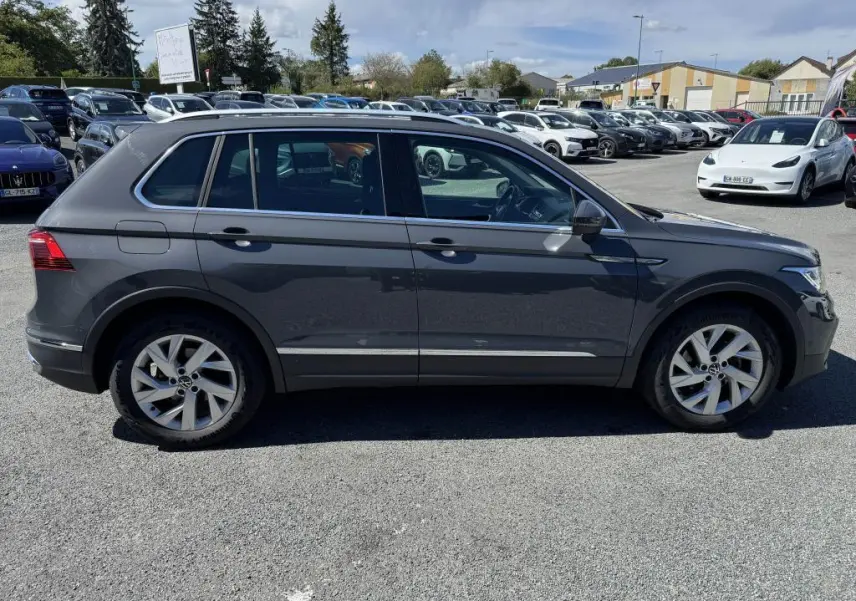Profil côté gauche d'un Volkswagen Tiguan gris Urano 2021, avec jantes alliage 18 pouces et vitres surteintées.
