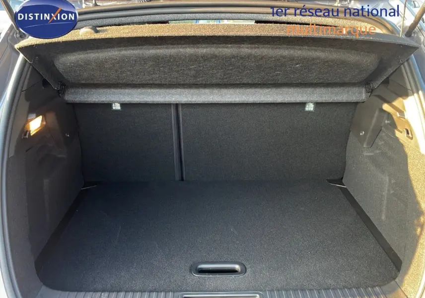 Coffre ouvert du Renault Captur E-Tech hybride 2025 gris cassiopée, montrant un espace de chargement propre et spacieux.