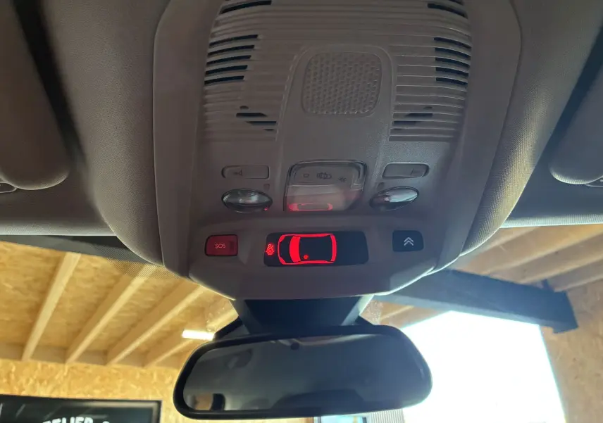 Vue intérieure du plafonnier du Citroën C5 Aircross 2025 avec commandes lumineuses et bouton SOS rouge.