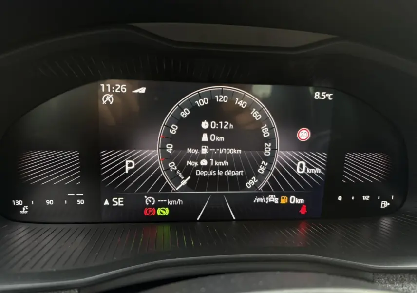 Affichage numérique du tableau de bord du Skoda Kamiq TSI 116 DSG7, montrant la vitesse et les alertes au repos.