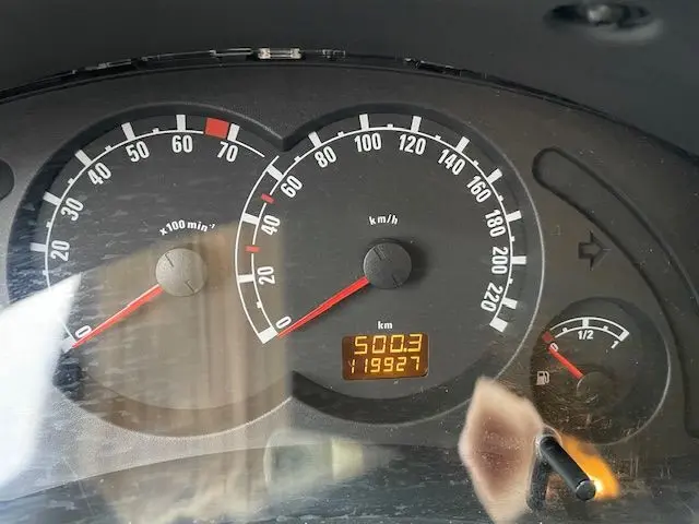 Tableau de bord de l'Opel Meriva grise 2010 montrant compteur, compte-tours et jauge carburant au ralenti.