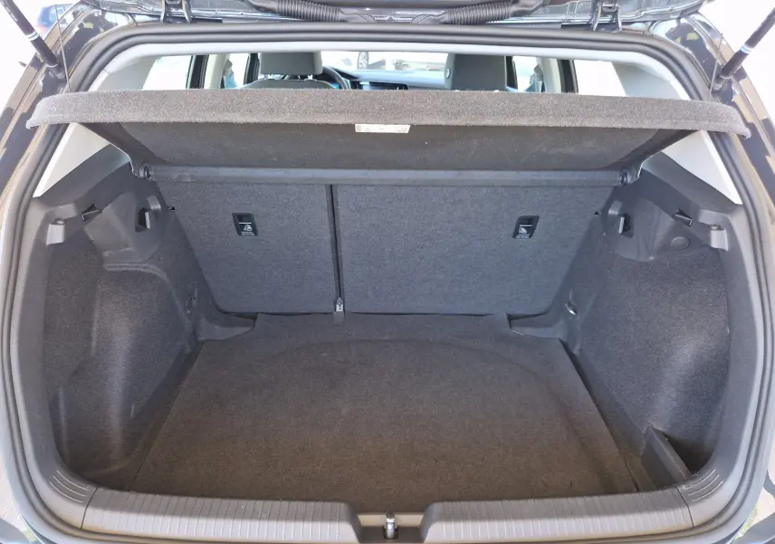 Coffre ouvert en vue arrière d'une Volkswagen Golf A8 2.0 TDI gris Urano, montrant un espace de chargement propre et spacieux.