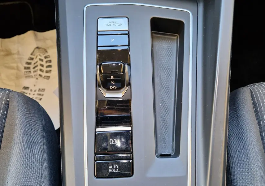 Vue en plongée sur la console centrale de la Volkswagen Golf A8 2023, avec levier de vitesses DSG et boutons de contrôle.