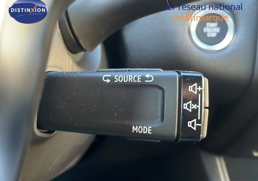 Commande au volant avec boutons source et mode, sur Renault Captur E-Tech hybride 2025, intérieur noir.