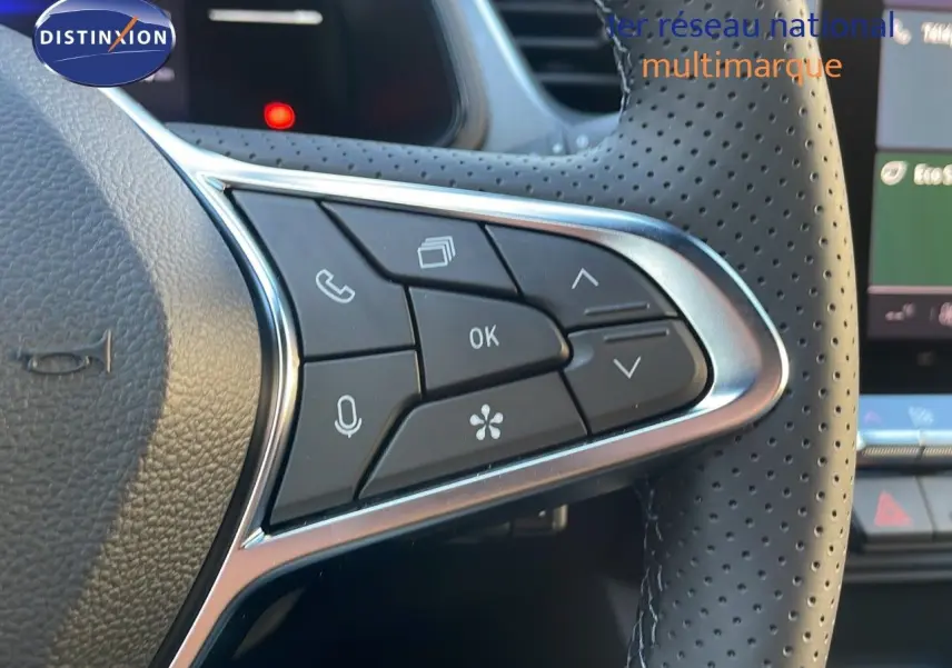 Gros plan sur les commandes du volant en cuir perforé du Renault Captur E-Tech gris cassiopée, version 2025.