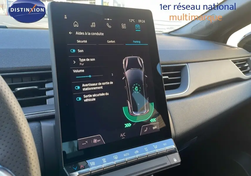 Vue intérieure du tableau de bord du Renault Captur E-Tech gris, avec écran tactile central affichant l'aide au stationnement.