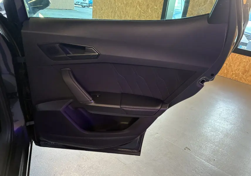 Porte arrière gauche ouverte du CUPRA Formentor gris foncé, intérieur noir avec surpiqûres et poignée intégrée.