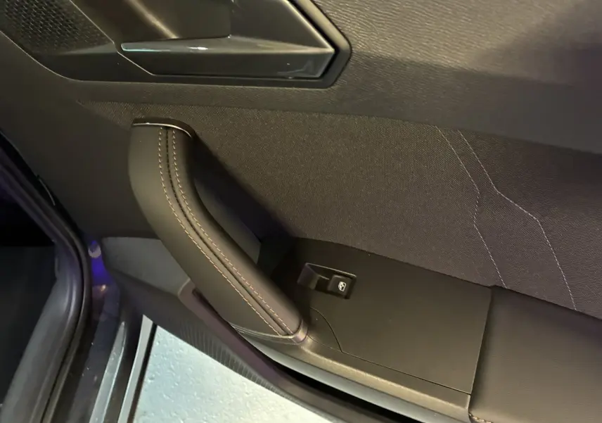 Poignée de porte intérieure en cuir noir avec surpiqûres marron sur CUPRA Formentor 2024, côté gauche.