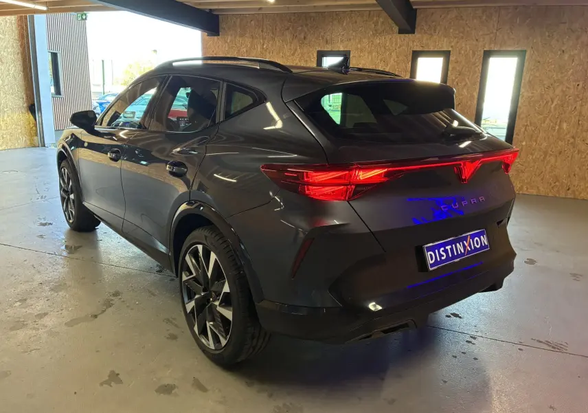 Vue 3/4 arrière droite du CUPRA Formentor gris foncé 2024 avec feux arrière LED et jantes bi-ton 19 pouces.