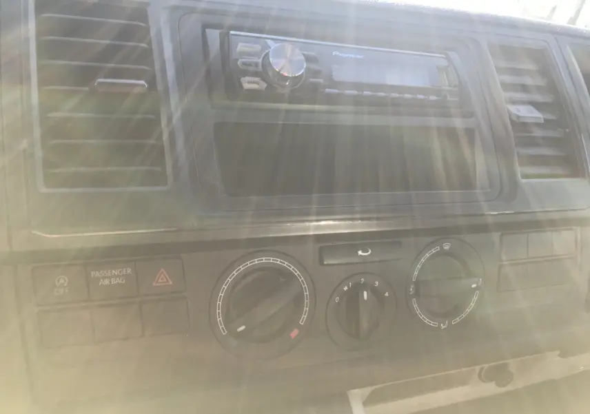 Tableau de bord du Volkswagen Transporter T6 blanc, vue rapprochée sur les commandes de climatisation et autoradio Pioneer.