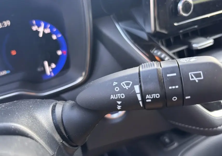 Gros plan sur la commande d'essuie-glace à gauche du volant dans l'habitacle d'une Toyota Corolla hybride 2020.